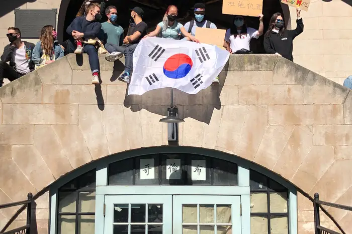 People at the Stop Asian Hate rally waving a Korean flag